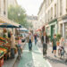 Illustration réaliste d’un quartier français animé avec un marché de fruits et légumes, une piste cyclable, un centre de santé et des habitants de différents âges.